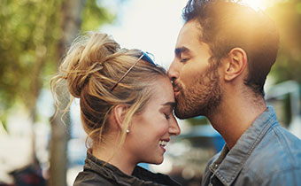 Man kissing woman's forehead