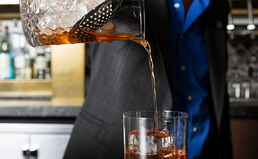 barista pouring a cocktail